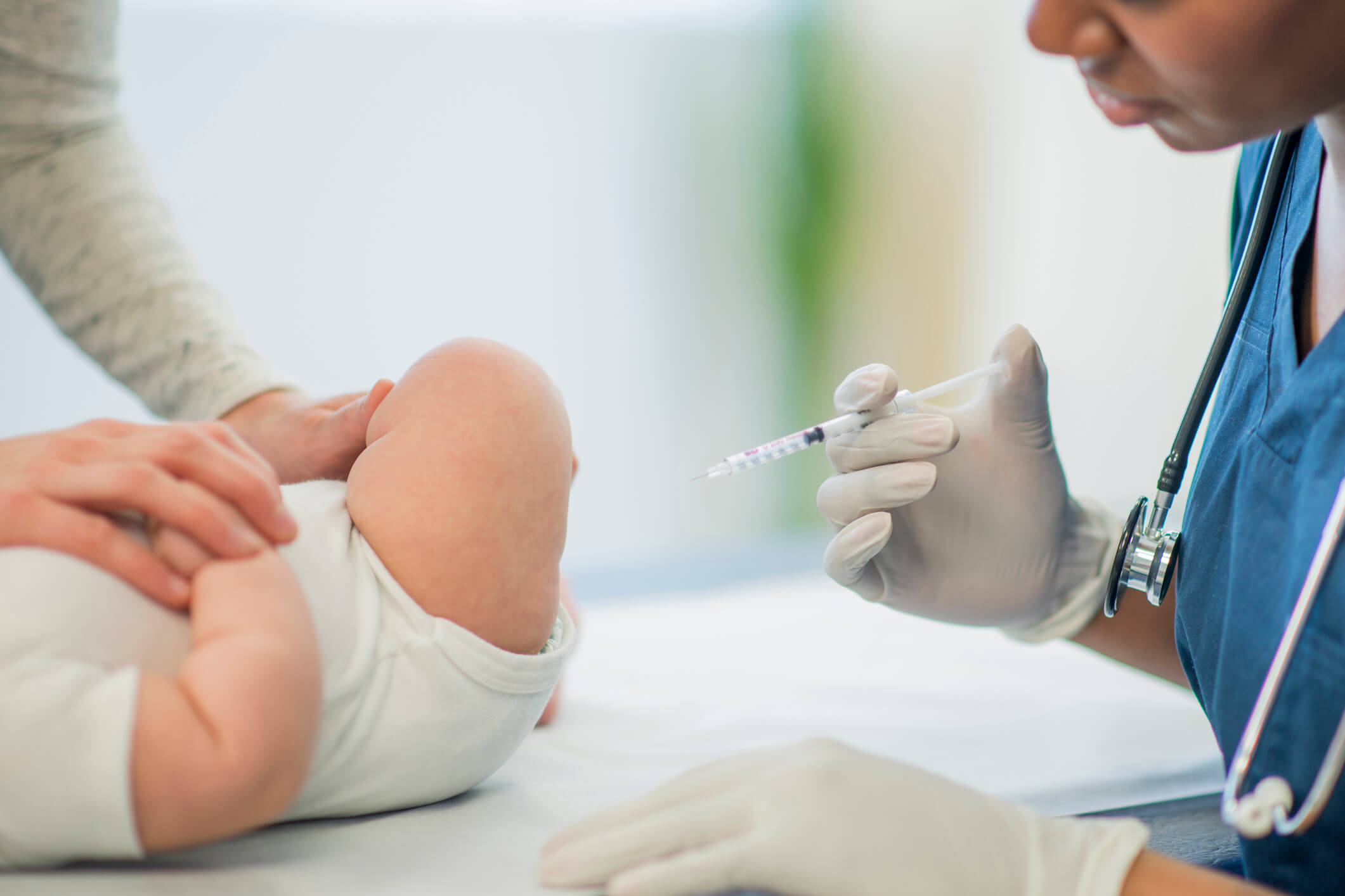 vacinas do bebê - médico apontando seringa para bebê
